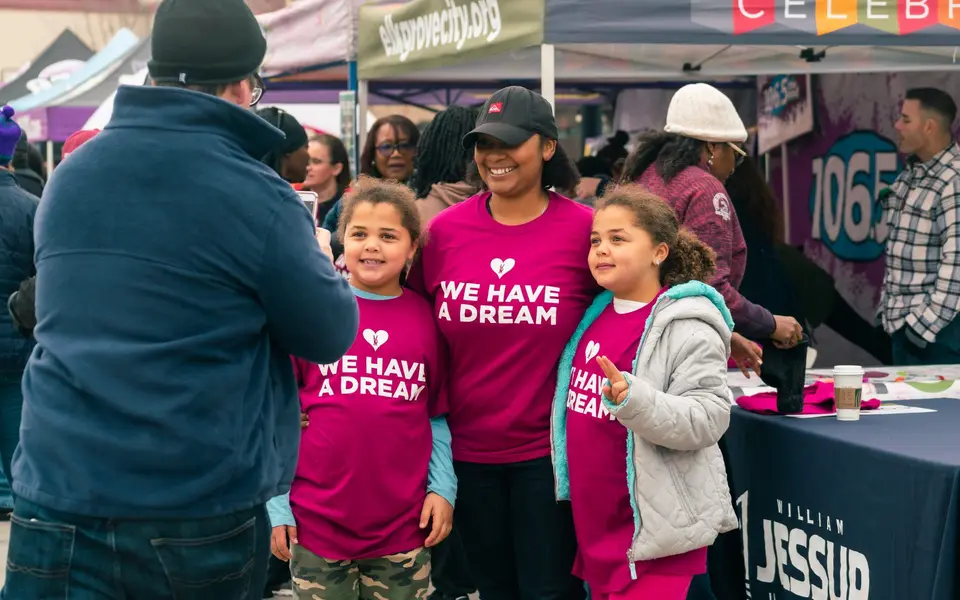 Children in "We have a dream" shirts at an Expo booth