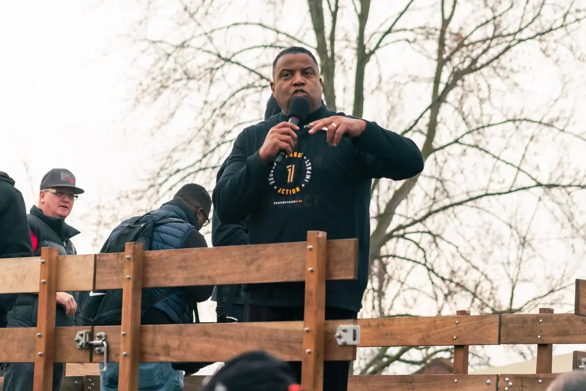 A leader speaks to the crowd before the Extra Mile steps off