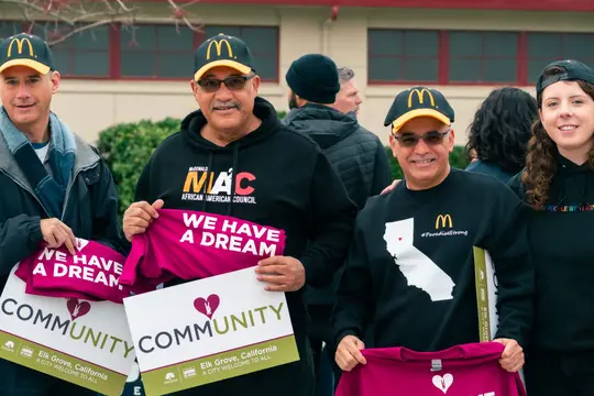 Marchers smile and hold up "We have a dream" and "Community" signs