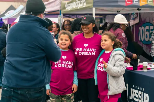 Children in "We have a dream" shirts at a booth inside the Expo