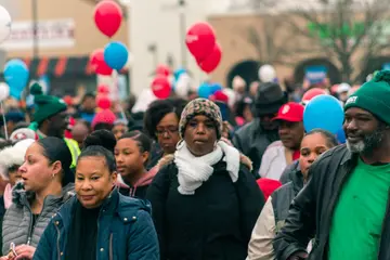 A crowd of marchers among red, white and blue balloons