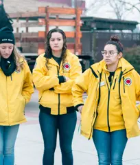 Volunteers in yellow jackets wait to help marchers